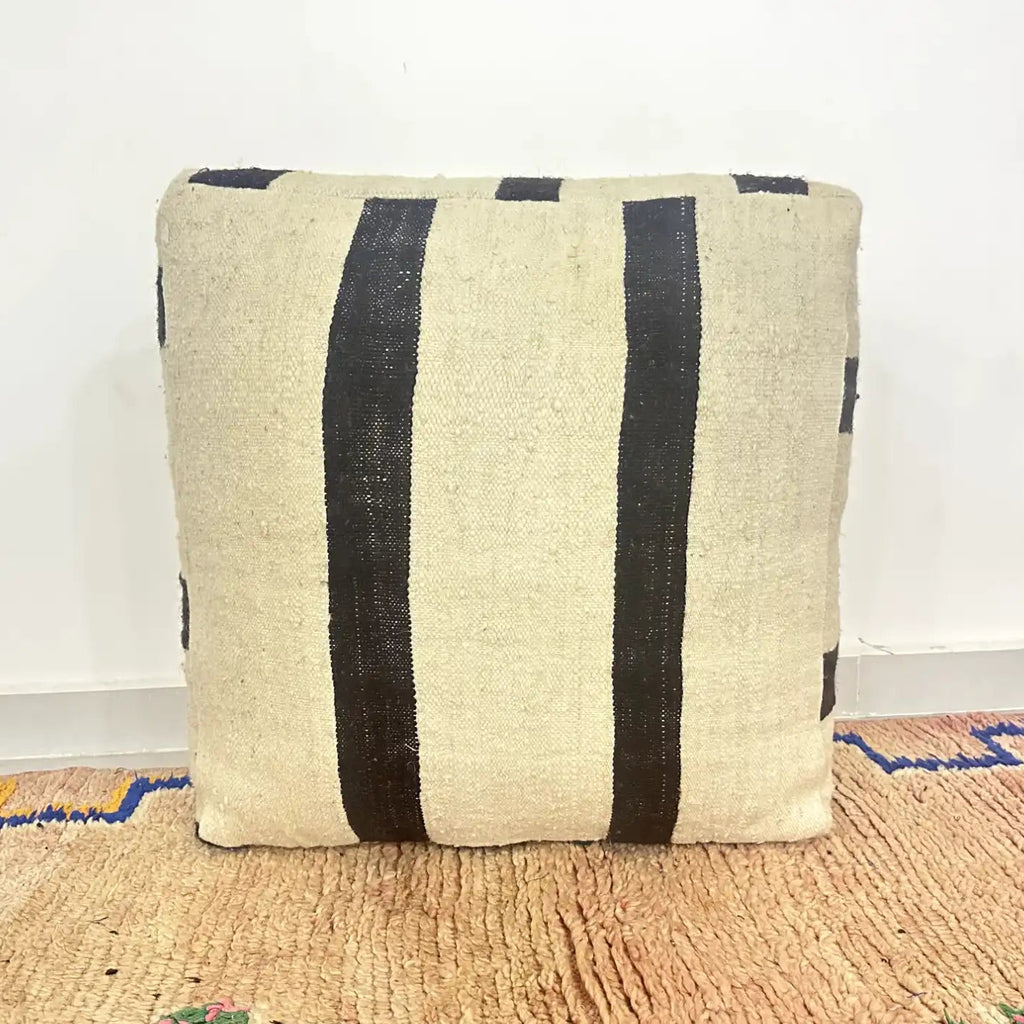 Handmade Moroccan kilim pouf featuring minimalist woven stripe bands, flatwoven Berber textile construction, and artisan handcrafted detailing
