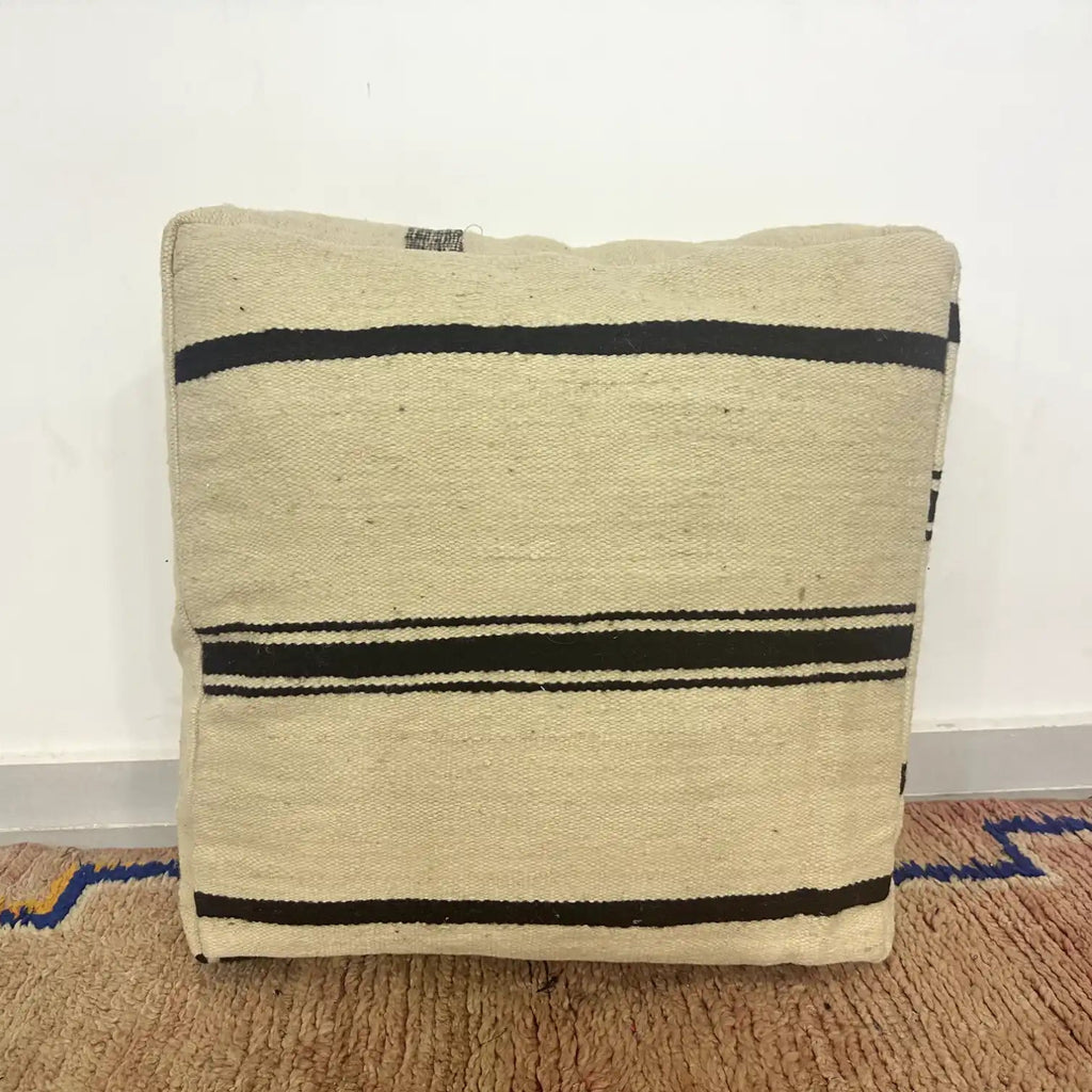 Handmade Moroccan kilim pouf featuring minimalist woven stripe bands, flatwoven Berber textile construction, and artisan handcrafted detailing.