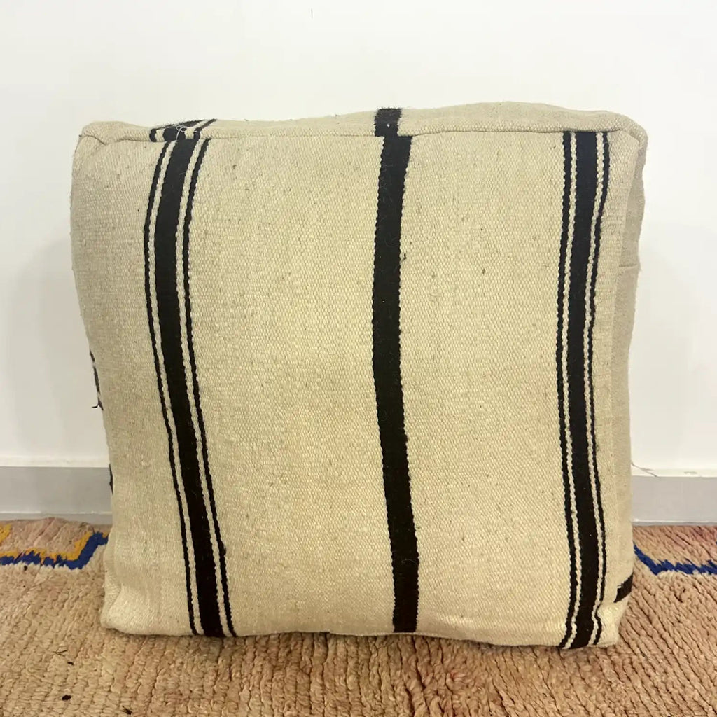 Handmade Moroccan kilim pouf featuring vertical stripe motifs, flatwoven Berber textile construction, and artisan handcrafted detailing.