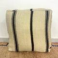 Handmade Moroccan kilim pouf featuring vertical stripe motifs, flatwoven Berber textile construction, and artisan handcrafted detailing.